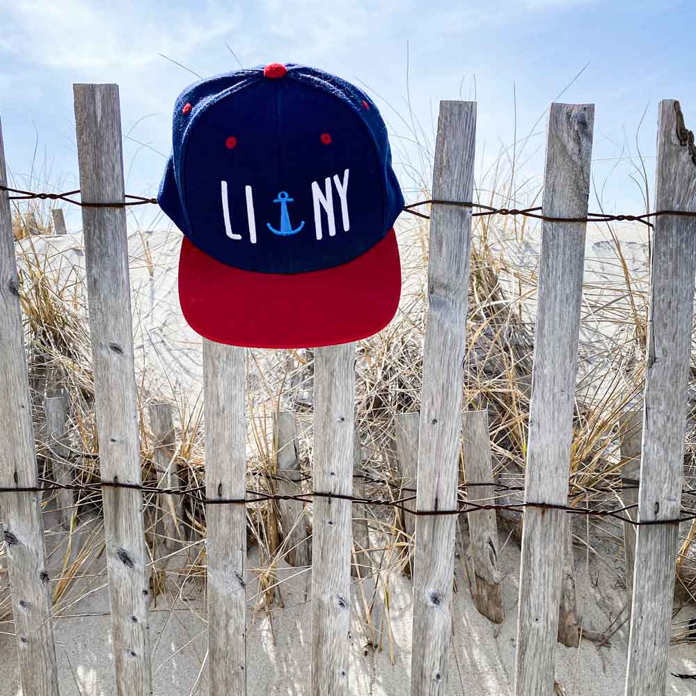 Navy LINY anchor Long Island New York snapback hat cap on beach drift wood dune fence